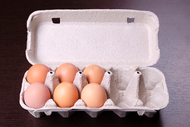 Cardboard egg rack with six red eggs and four empty cells