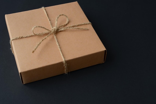 Cardboard gift box on a black background Present packing in eco friendly craft paper box