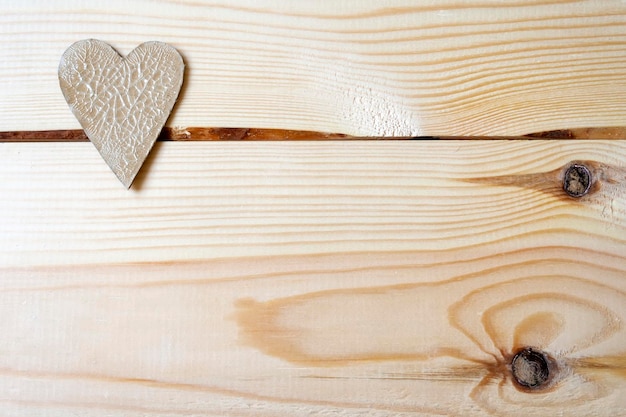 Cardboard heart with cracks lying on a wooden background