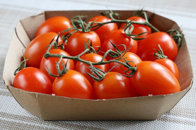 Cardboard packaging with red tomatoes on branch fresh vegetables for healthy eating