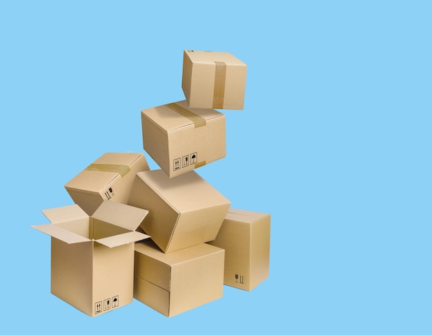 Cardboard parcel boxes falling on blue background