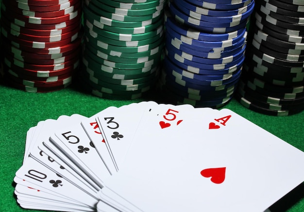 Cards and chips for poker on green table