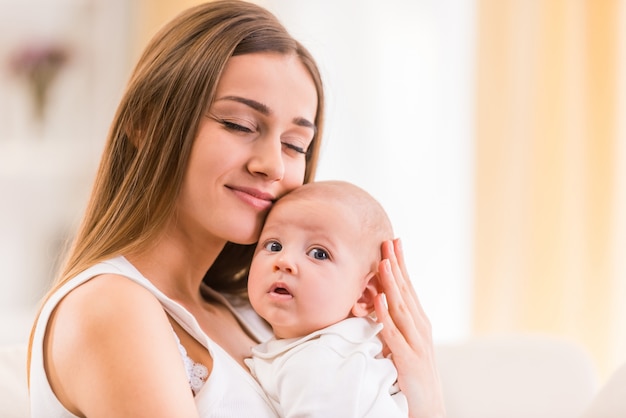 Care mom gently hugs the little kid.