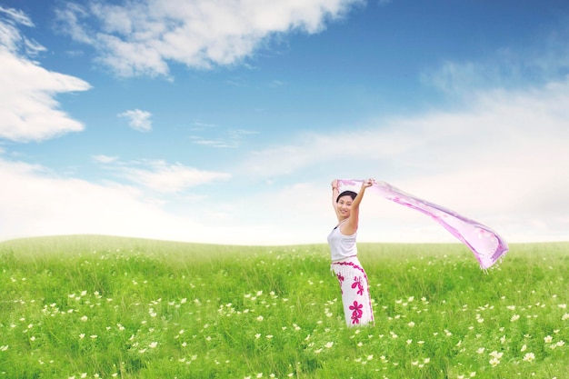 Photo carefree beautiful asian woman holding fabric on blossom meadow summer or spring concept