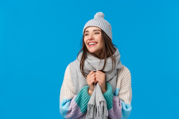 Carefree cheerful laughing and smiling brunette woman in winter hat, scarf and sweater