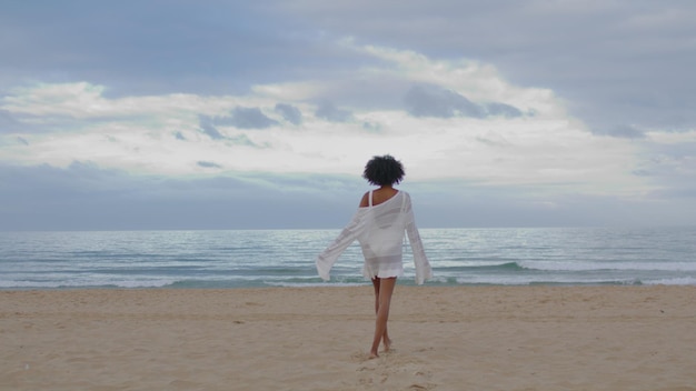 Carefree girl running beach rear view happy sexy woman enjoying peaceful sand