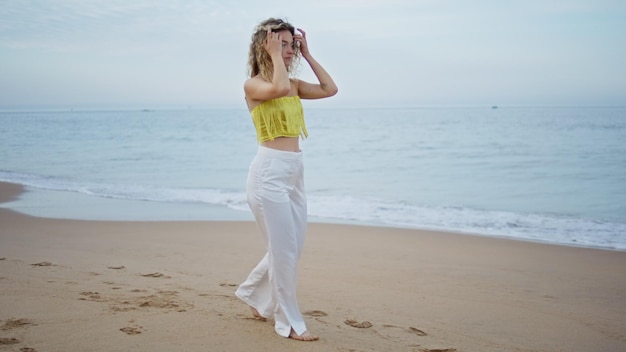 Carefree girl walking beach alone looking ocean view woman stepping on wet sand