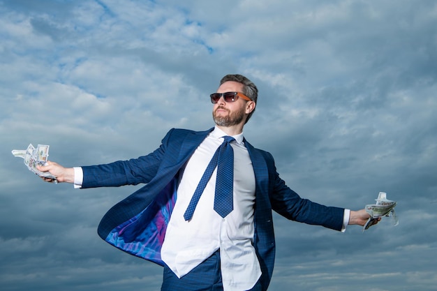 Photo carefree millionaire man with money outdoor millionaire man with money in suit photo of millionaire man with money millionaire man with money on sky background