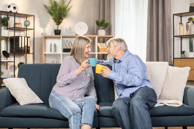 Carefree pensioners enjoying coffee and talking at home