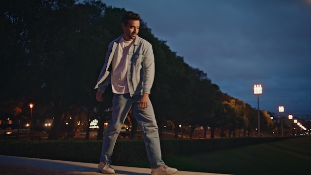 Carefree tourist enjoy evening in town park happy latin man walking on railings