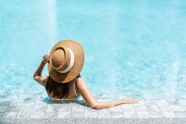 Carefree woman relaxing in swimming pool. Summer and holiday concept. Rear view, close up