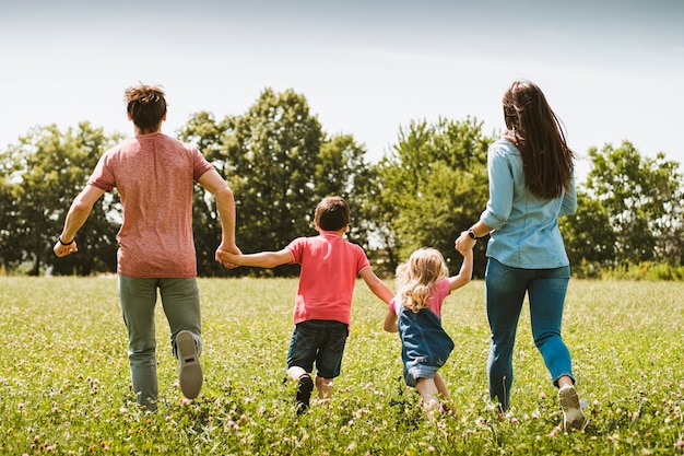 Carefree young family running through a meadow