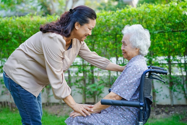 Caregiver help Asian elderly woman disability patient in nursing hospital medical concept