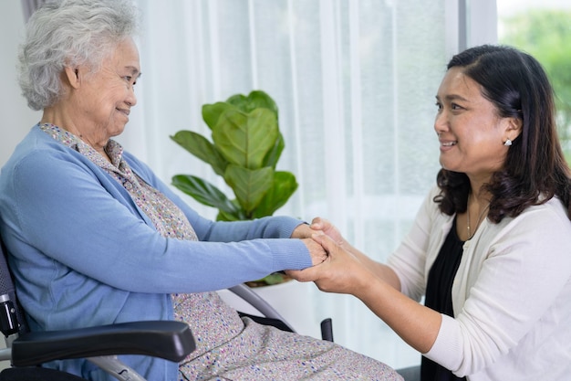 Caregiver help Asian senior or elderly old lady woman sitting on wheelchair at home