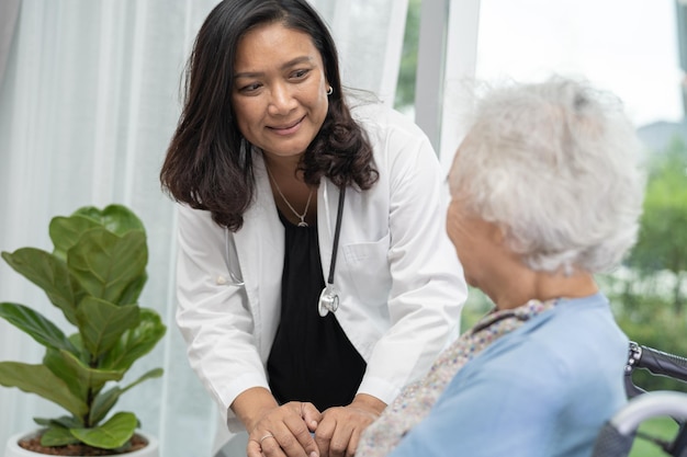 Caregiver help and care Asian senior or elderly old lady woman patient sitting on wheelchair at hospital healthy strong medical concept