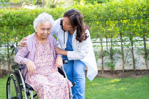 caregiver help and care Asian senior woman patient sitting on wheelchair at nursing hospital ward healthy strong medical concept