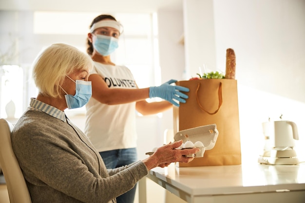 Caregiver supplying provisions for a senior lady