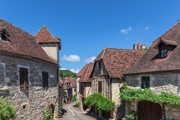 Carennac village masonry houses with tiled roofs decorated with ivy and flowering house plants Lot