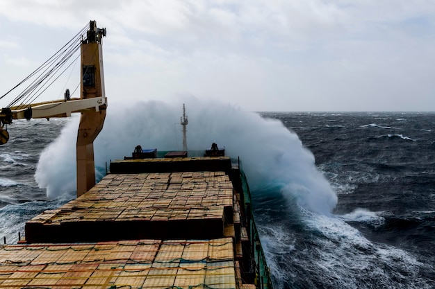 Cargo vessel with deck cargo at stormy sea View from navigational bridge Stormy sea Bad weather Gale Rough sea