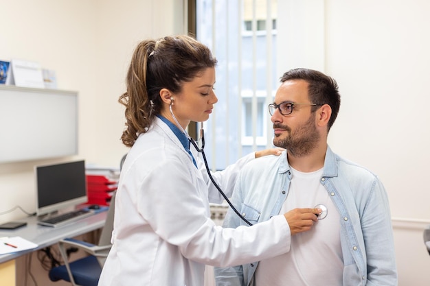 Caring Caucasian female doctor use phonendoscope examine male patient heart rate at consultation in hospital Woman nurse or GP use stethoscope listen to man heartbeat in clinic