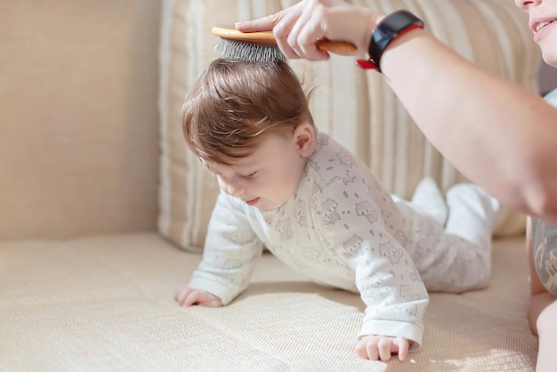 Caring mom combs her baby