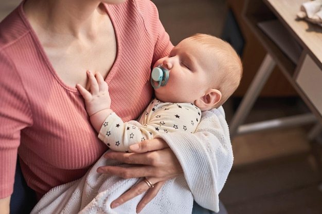 Photo caring mother holding sleepy baby