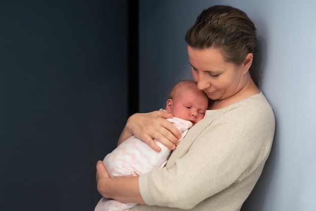 Caring young mother hold lean to chest newborn relax enjoy tender family moment at home