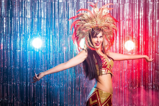 Carnival dancer and holiday concept beauty brunette woman in cabaret suit and headdress with natural