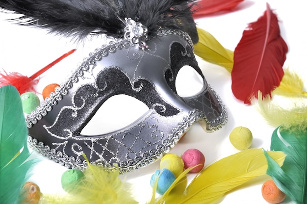 Carnival mask among colorful feather 