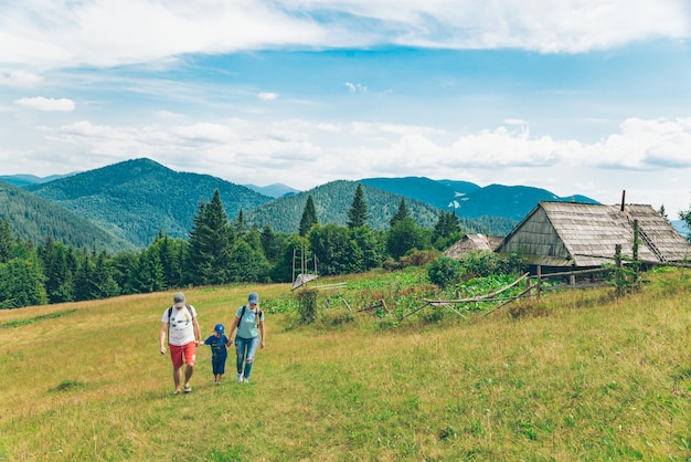 CARPATHIAN MOUNTAINS UKRAINE August 5 2018 family of three persons walking by carpathian mountains