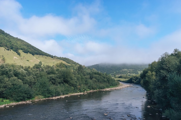 Carpatian summer landscape Beautiful mountains and river on the blue sky background