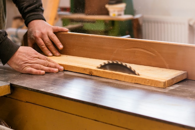 Carpenter cutting a wooden plank