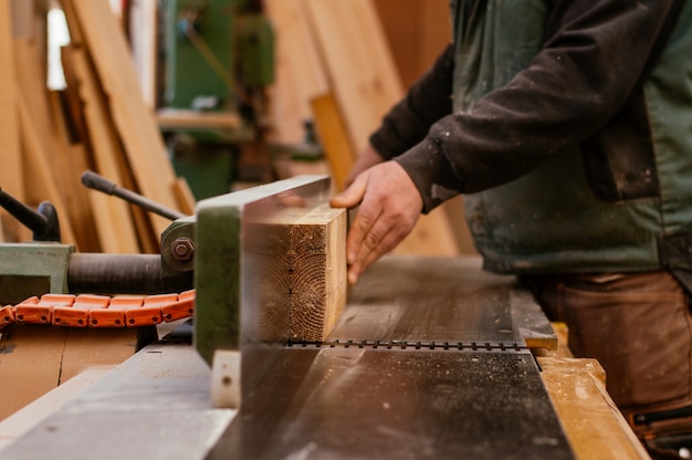 Carpenter cutting wooden plank.