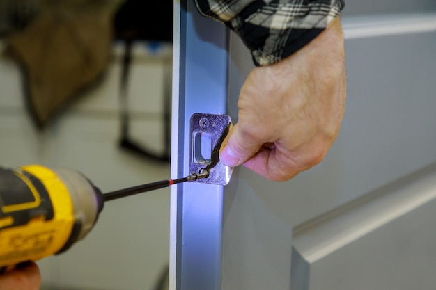 Carpenter installation at interior wood door lock of an apartment