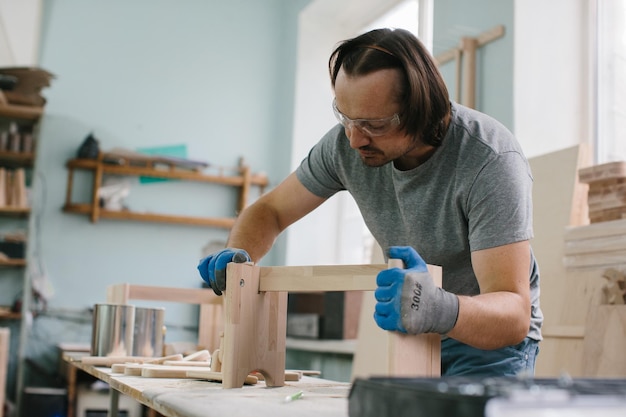 A carpenter makes children's furniture in a carpentry workshop