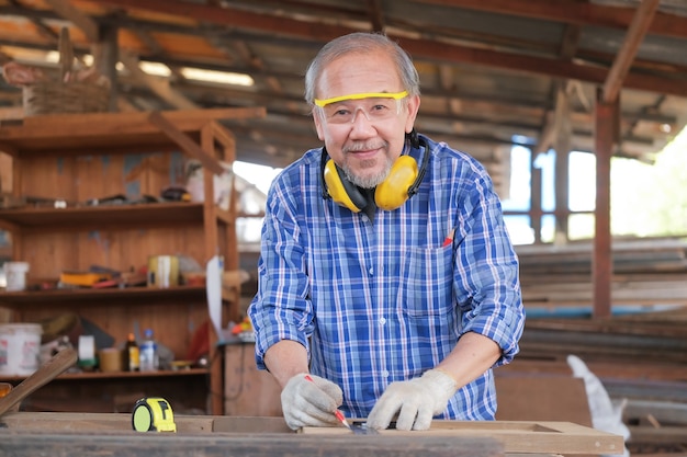 Carpenter men work on the measurements of wood in a carpentry shop.