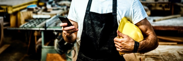 Carpenter texting someone and holding his helmet