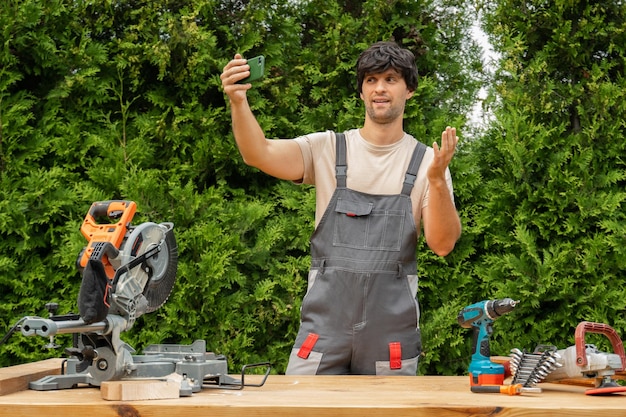 Carpenter using camcorder in workshop Caucasian male craftsperson with camera recording DIY tutorial