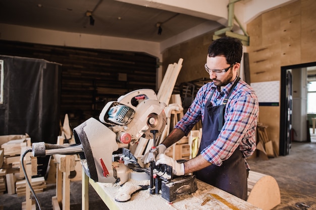 Carpenter Using Circular Saw for wood at his workshop