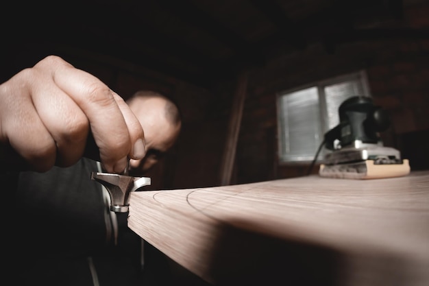 Carpenter with hand electric router machine at work Trying on a cutter