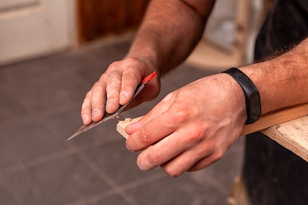 A  carpenter in work clothes restoring a wooden bar