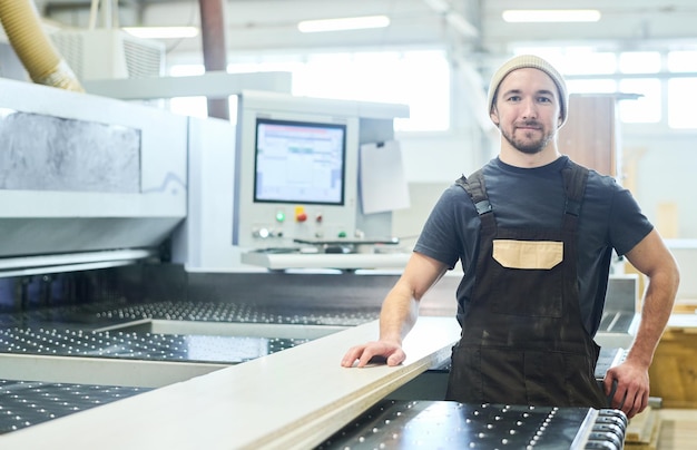 Carpenter working at machine at factory