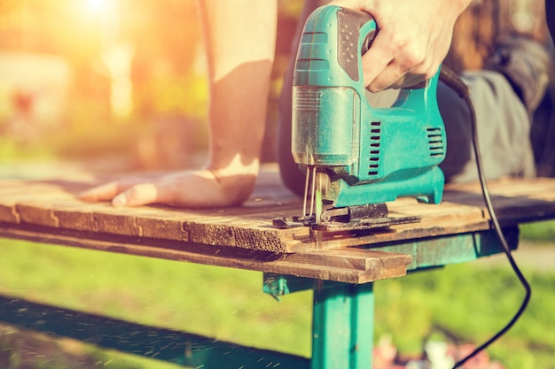 Carpenter working with electric jigsaw