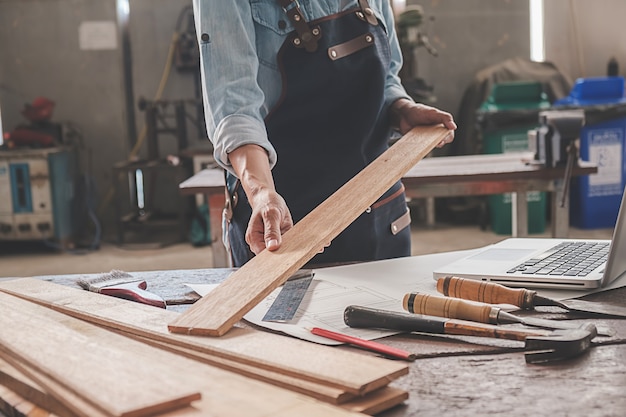 Carpenter working with equipment on wooden table in carpentry shop. woman works in a carpentry shop. 