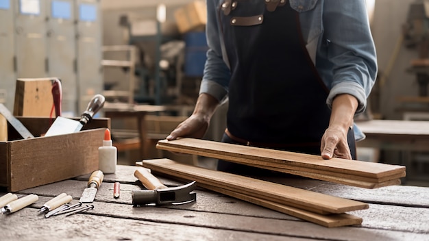 Carpenter working with equipment on wooden table in carpentry shop. woman works in a carpentry shop.