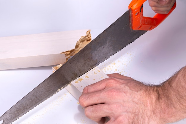 Photo a carpenter works on a handsaw to cut a broken wooden board