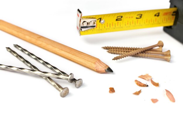 Photo carpenters pencil with sharpening shavings tape measure framing nails and deck screws