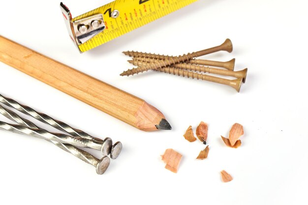 Photo carpenters pencil with sharpening shavings tape measure framing nails and deck screws