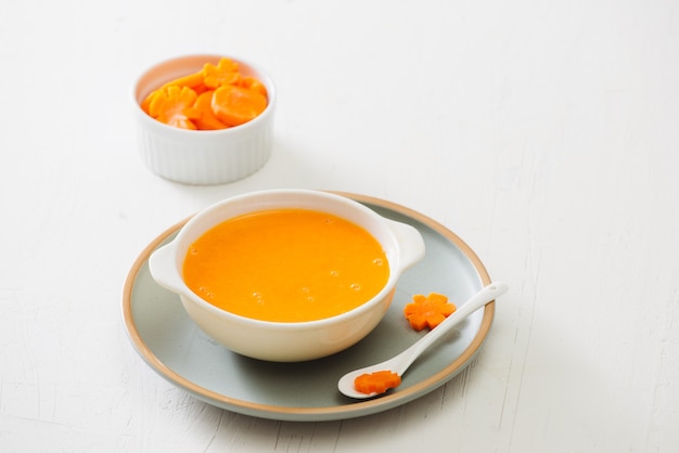 Carrot baby puree in bowl isolated on light background