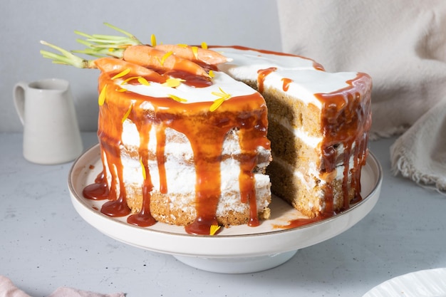 A carrot cake with a slice cut out of it